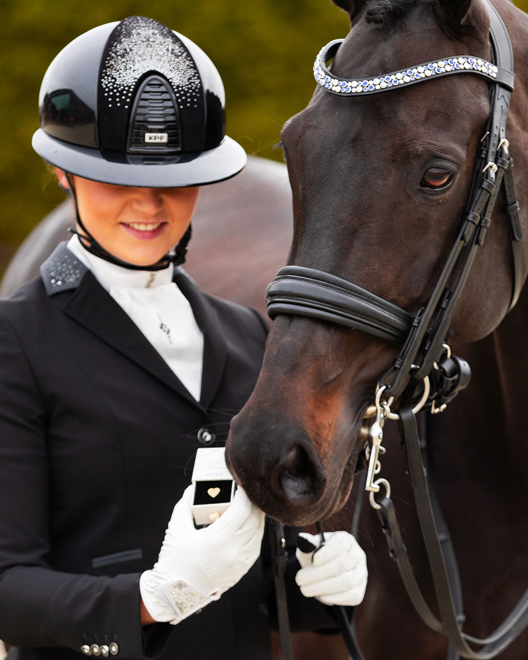 Model holding the giftbox including the JuulC Good Vibes Pin next to her horse
