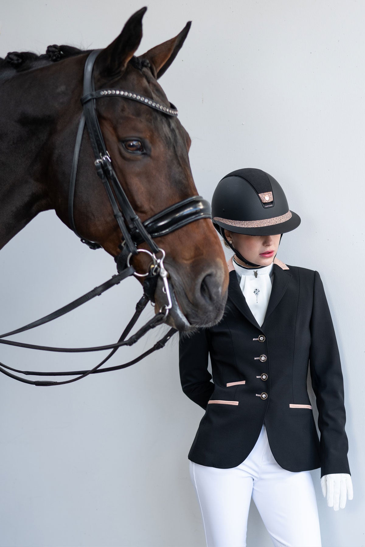 JuulC Ladies' Show Coat in Black Shimmer with pink and rosegold accents, worn by model with horse
