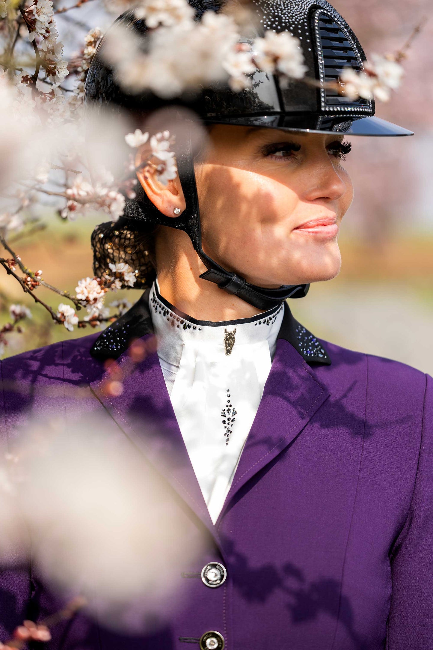 Detail of JuulC' Shadow Amethyst Show Jacket in purple with black accents and Swarovski details, worn by model with matching stock-tie